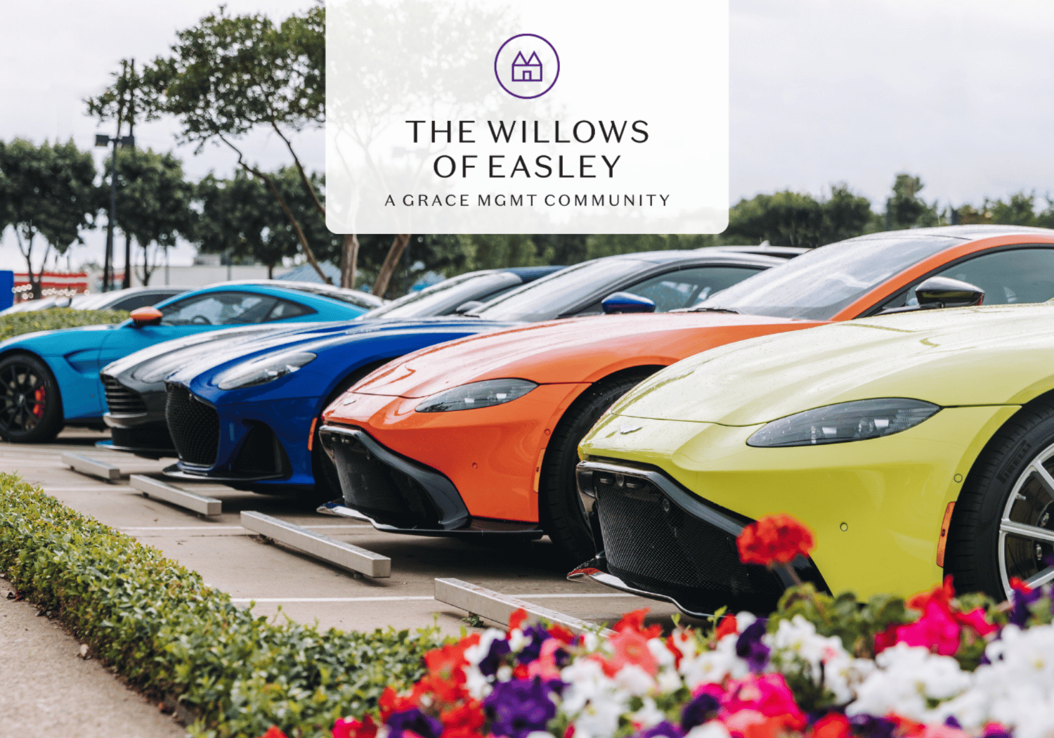 Row of colorful sports cars parked in a lot with a translucent banner reading The Willows of Easley, A Grace MGMT Community.
